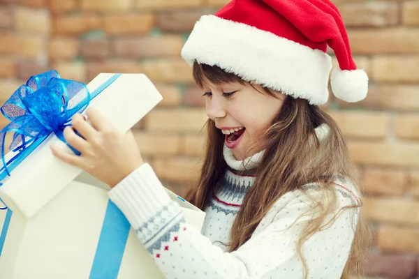 Nettes glückliches Teenager-Mädchen mit Weihnachtsmann in einer Geschenkschachtel. Weihnachtskind. — Stockfoto