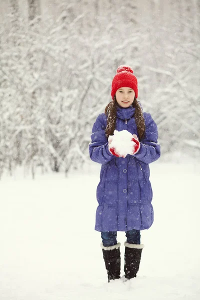冬の屋外を歩く少女の肖像画です。雪と遊ぶ。子供の屋外. — ストック写真