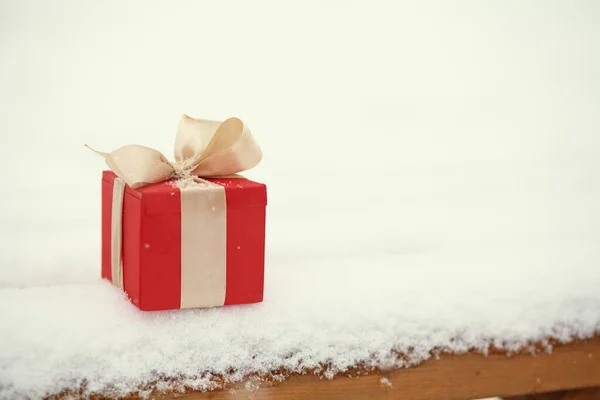 Röd jul presentförpackning på vintern snö utomhus. — Stockfoto