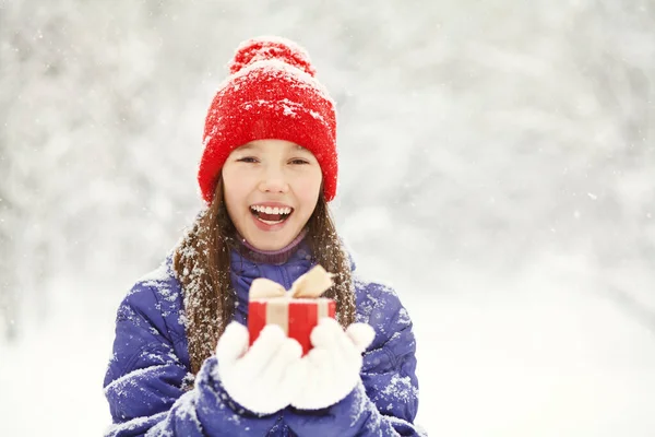 Pretty teenage girl with a gift in her hands. adolescent winter outdoors. — Stock Photo, Image