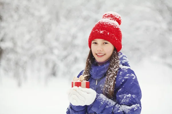 Linda adolescente con un regalo en sus manos. adolescente invierno al aire libre. — Foto de Stock