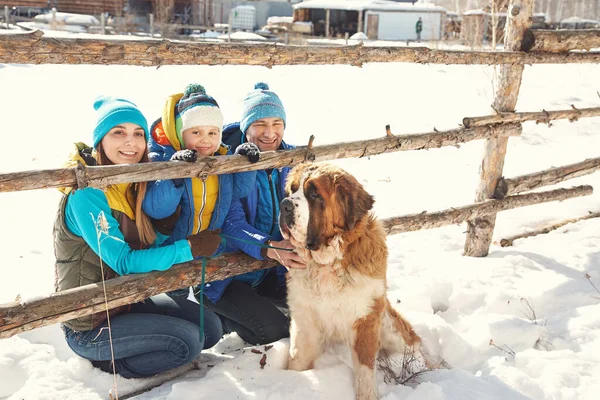 Gelukkig spelen familie met St. Bernard hond in de winter. mensen buiten — Stockfoto