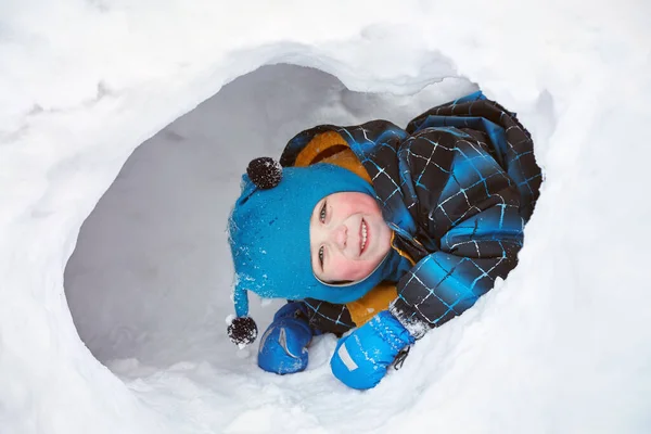 Kar evinde oynayan komik küçük çocuk. — Stok fotoğraf