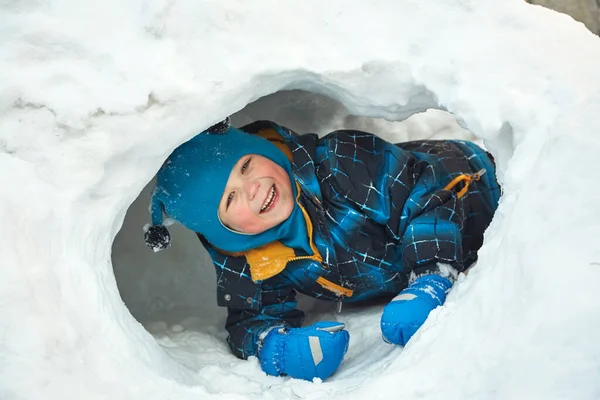 Drôle petit garçon jouer dans la maison de neige — Photo
