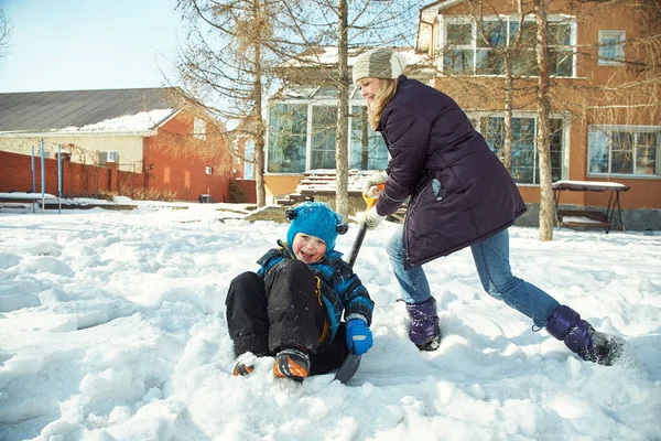 family playing with snow in the winter outdoors