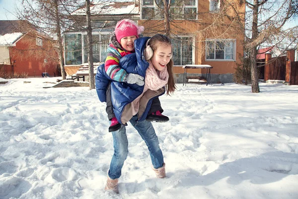 Kinder spielen im Winter im Hof seines Hauses im Freien lizenzfreie Stockfotos