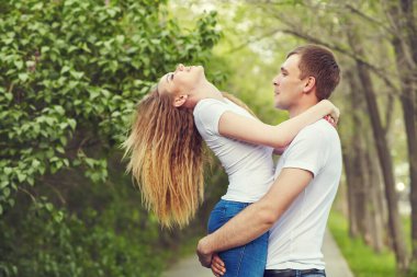 Dışarıda aşık genç ve mutlu bir çift. Parktaki sevecen adam ve kadın.