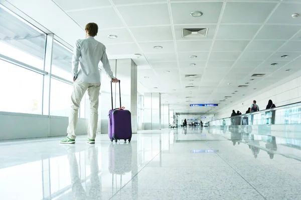 Viajero hombre con una maleta en el aeropuerto. —  Fotos de Stock