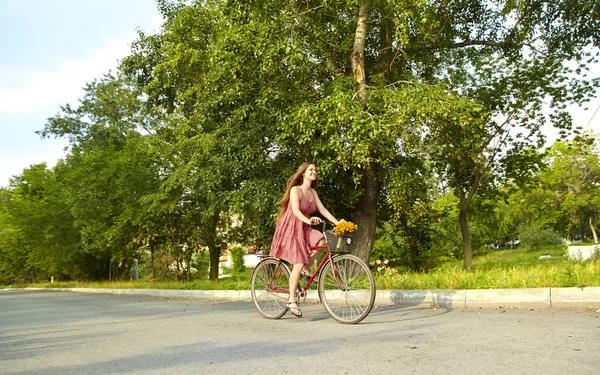 Jovem mulher e bicicleta — Fotografia de Stock