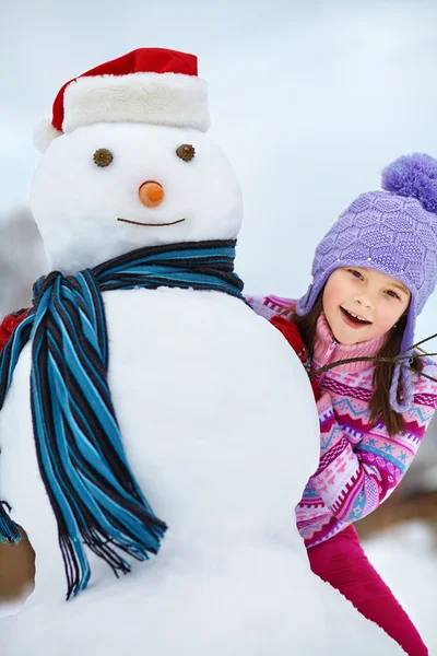 Miúdo brincando com boneco de neve — Fotografia de Stock