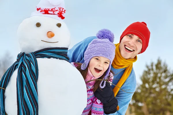 Vader en dochter met sneeuwpop — Stockfoto