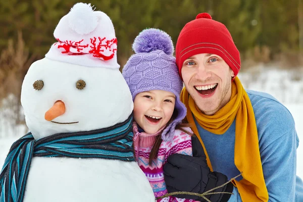 Vater und Tochter mit Schneemann — Stockfoto