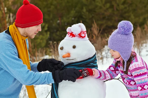 Padre e figlia con pupazzo di neve — Foto Stock