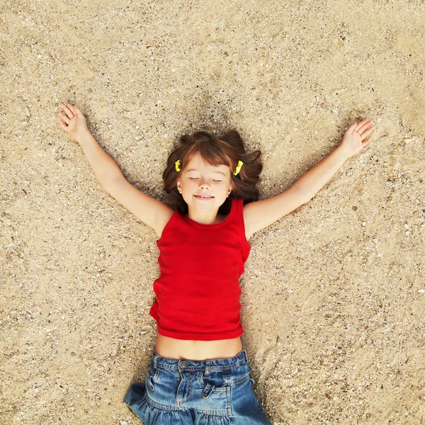 Meisje liggend op het zand — Stockfoto