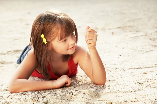 Meisje liggend op het zand — Stockfoto