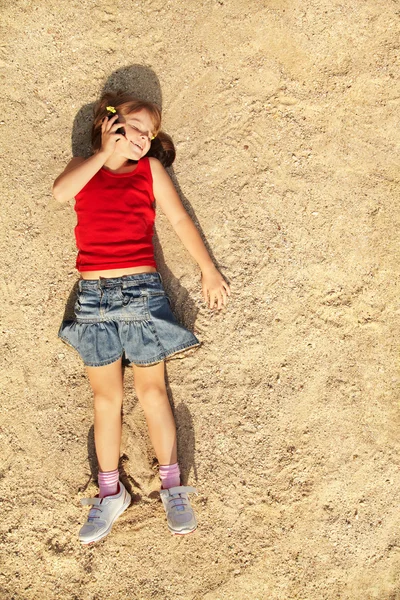 Meisje liggend op het zand — Stockfoto