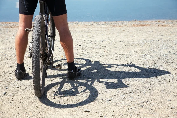在山的湖面上的自行车的人 — 图库照片