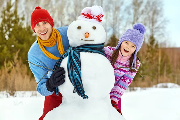 Vater und Tochter mit Schneemann — Stockfoto