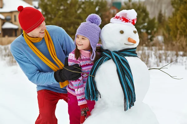 Vater und Tochter mit Schneemann — Stockfoto