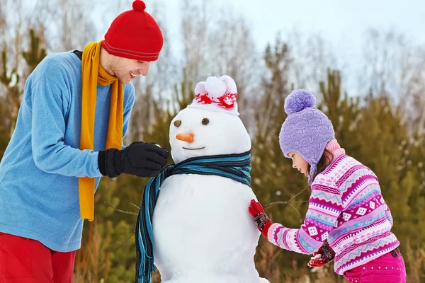 Pai e filha com boneco de neve — Fotografia de Stock