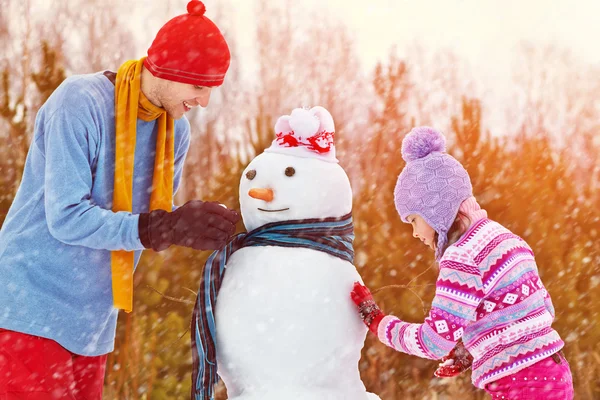 Padre e hija con muñeco de nieve — Foto de Stock