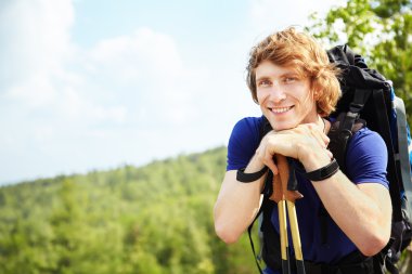 Sırt çantalı bir adam dağda yürüyüş yapıyor.