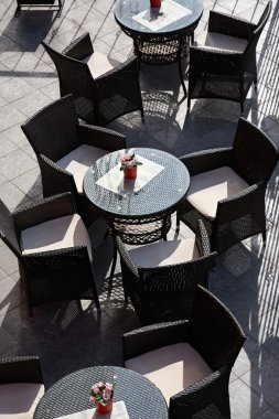 Kafe terasında boş masalar ve sandalyeler.