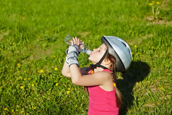 Liten flicka i rullskridskor i en park — Stockfoto