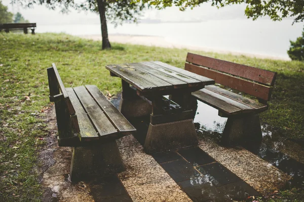 Picknickbord och bänkar i en park på en regnig dag — Stockfoto