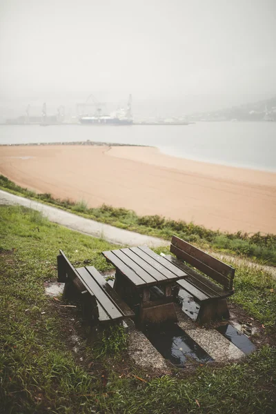 Picknickbord och bänkar i en park på en regnig dag — Stockfoto