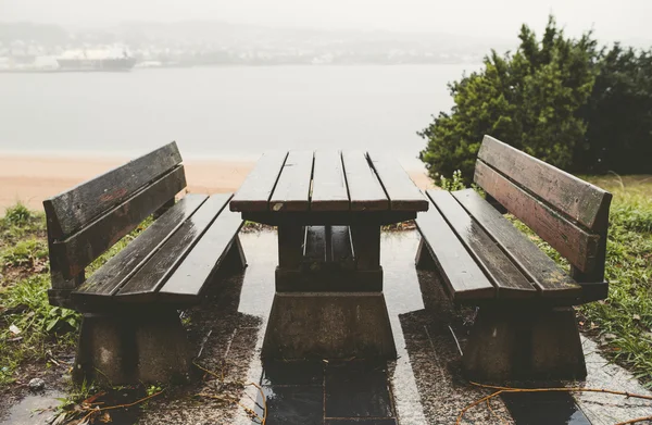 Tavolo da picnic e panchine in un parco in un giorno di pioggia — Foto Stock