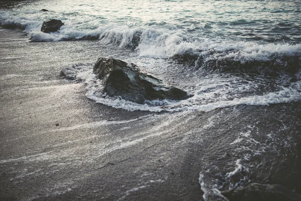 Detail of the shore of the beach with sand, rock and waves — Stock Photo, Image