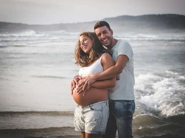 Casal grávida na praia — Fotografia de Stock