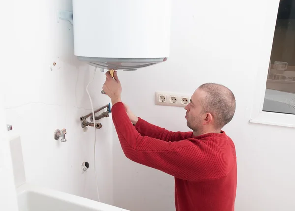 Loodgieter herstellen een elektrische ketel — Stockfoto