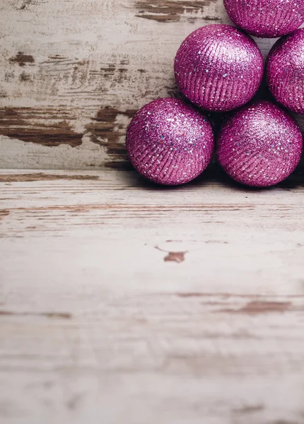 Pink christmas balls in a stack over wooden background — Stock Photo, Image