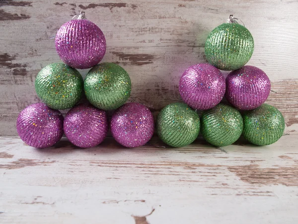 Bolas de Natal rosa e verde em uma pilha sobre fundo de madeira — Fotografia de Stock