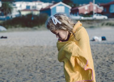 Kız sahilde bir havlu ile kurutma