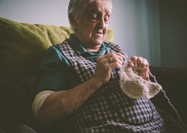 Elderly woman sewing at home