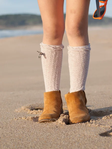 Ботинки маленькой девочки на пляже на открытом воздухе — стоковое фото