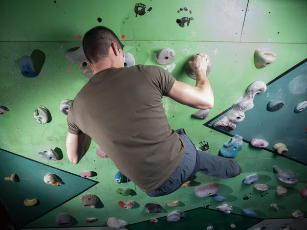 Ung man klättra väggen rock — Stockfoto