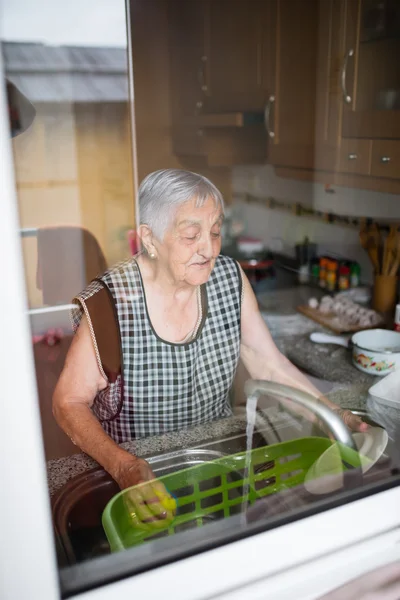 Femme âgée lavant la vaisselle — Photo