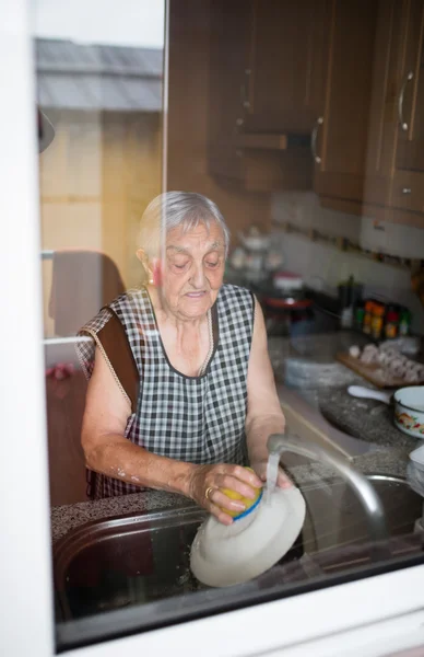 Femme âgée lavant la vaisselle — Photo