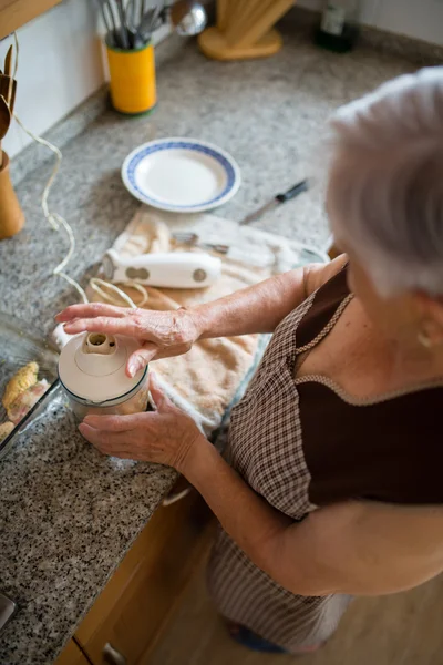 Femme âgée cuisine dans la cuisine — Photo