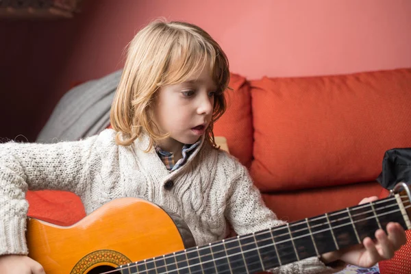 Liten blond pojke spelar spansk gitarr — Stockfoto