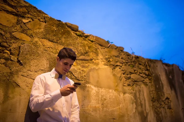 Eleganter Mann mit Fliege schaut auf sein Smartphone — Stockfoto