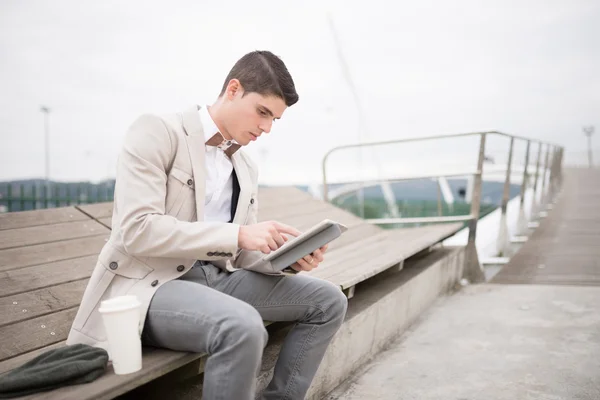 Elegant businessman with bow tie working with a tablet — Stock Photo, Image