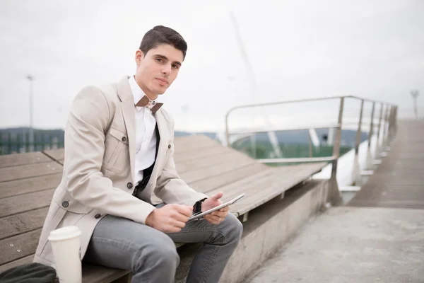 Elegant businessman with bow tie working with a tablet — Stock Photo, Image