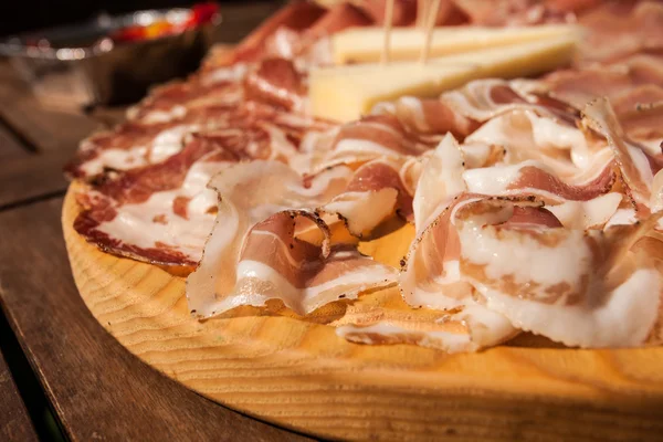 Vleeswaren op een houten snijplank. — Stockfoto