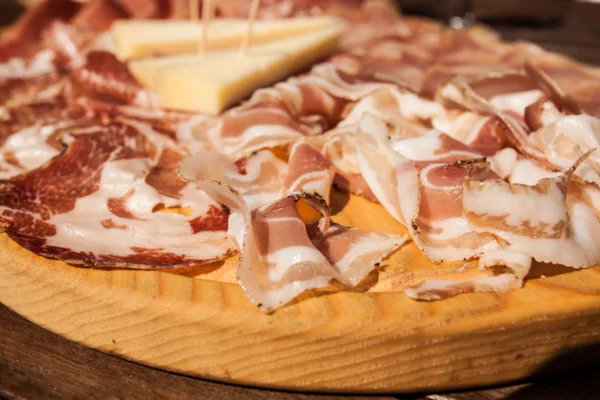 Salumi su un tagliere di legno . — Foto Stock