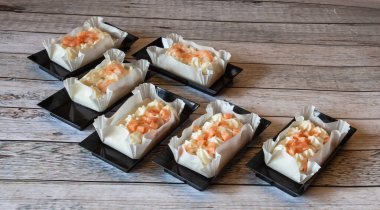 Somon ve karides kanepeleri dikdörtgen siyah plastik tepsilerde iştah açıcı, doğal ışık.